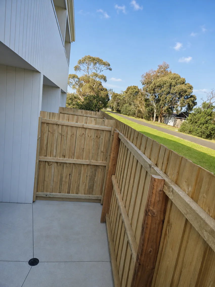 Timber side fence and gate beside a white weatherboard home